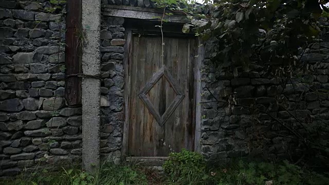 一个古老的石头建筑的木门。棕色的木门，白色的石墙镶边。视频素材
