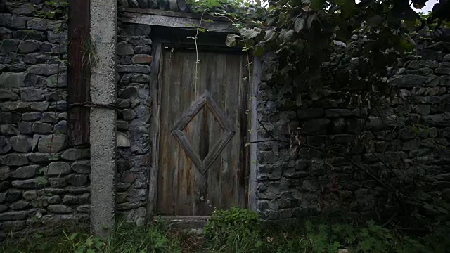一个古老的石头建筑的木门。棕色的木门，白色的石墙镶边。视频素材