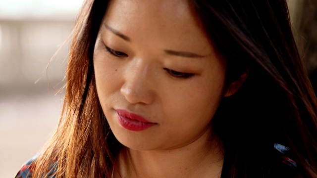 迷人的、性感的年轻中国女人在户外抚摸她的头发视频素材