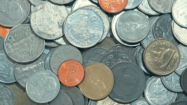 特写俯视图动作旋转投泰国币，概念省钱视频素材