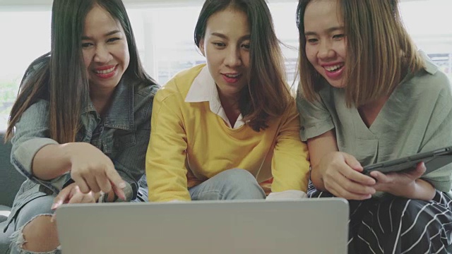 迷人的年轻亚洲女孩群的朋友一起看网上购物电脑。视频素材