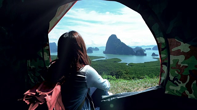 迷人的亚洲女游客坐在帐篷里看山，感受自由和享受自然的4K慢镜头，在samenang Chee，旅行和幸福的生活理念视频素材