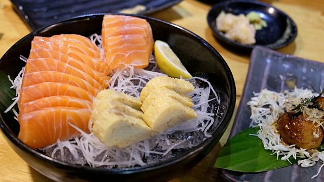 4K吊车拍摄:近距离拍摄日本食物菜单，生鱼片鲑鱼和日本田鸡蛋的冰视频素材