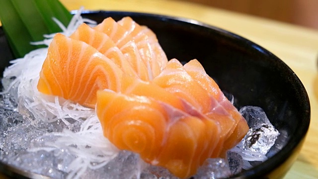 4K吊车拍摄:近距离拍摄日本食物菜单上的冰生鱼片鲑鱼视频素材