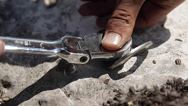 这个男人的手扭钥匙螺栓进入岩石的特写。视频下载
