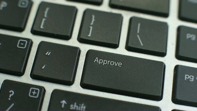 电脑键盘上的批准按钮，女性手指按下按键视频素材