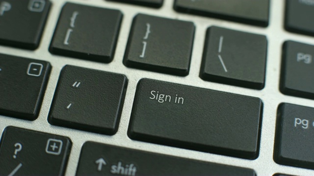 电脑键盘上的登录按钮，女性的手指按下键视频素材