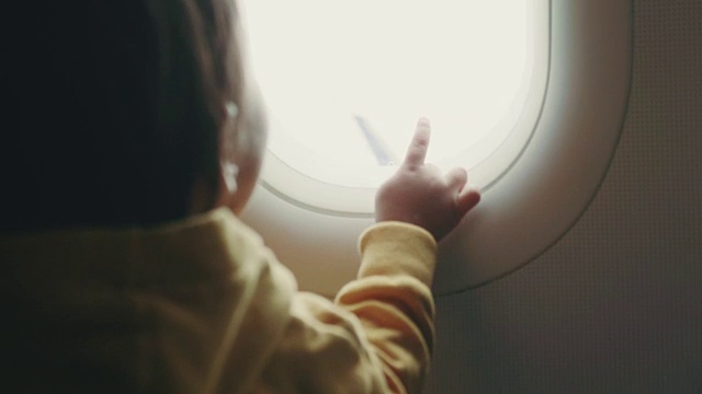 幼童正在通过窗户看全景飞机视频下载
