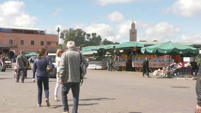 游客，出租车和活动Djemaa el Fna显示库图比亚尖塔，马拉喀什，摩洛哥，北非，非洲视频下载