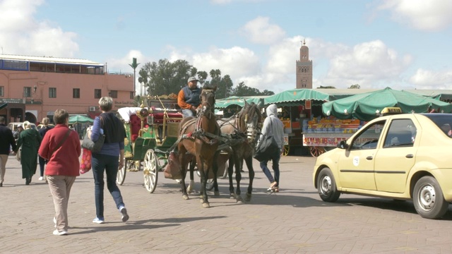 非洲，北非，摩洛哥，马拉喀什，联合国教科文组织世界遗产库图比亚尖塔上的游客、出租车和活动视频下载