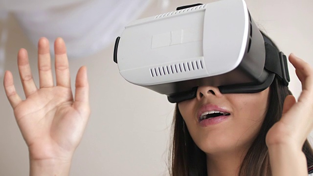戴着VR头戴在虚拟现实中玩视频游戏的女人视频素材