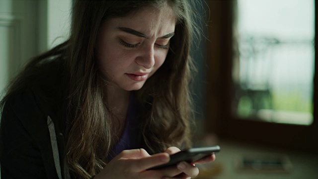 悲伤的女孩在手机短信的特写/雪松山，犹他州，美国视频素材