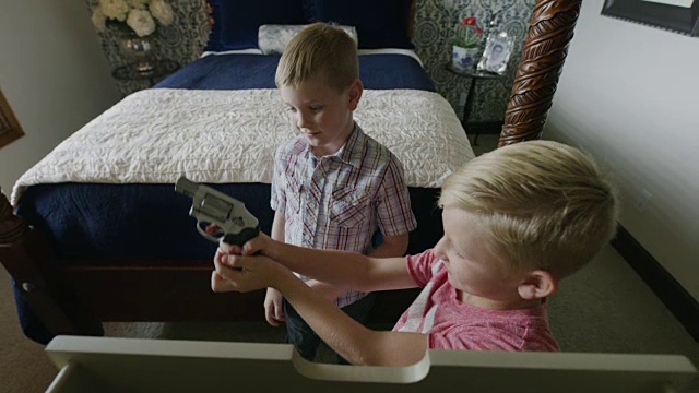 美国犹他州雪松山，男孩偷偷溜进卧室，然后发现并玩枪视频素材