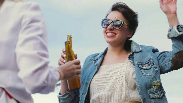 在户外聚会上喝啤酒跳舞的漂亮女人视频素材