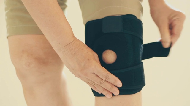 亚洲女性膝关节受伤时，用膝盖支撑支架支撑腿部视频下载