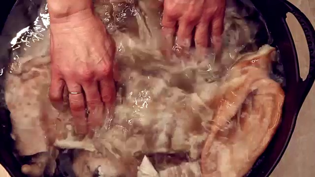 人把肉和水放在锅里。前视图。视频下载