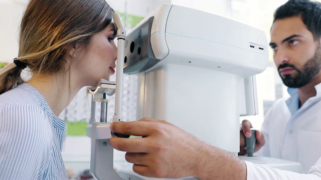 视力测试。验光师在现代设备上测试女性视力视频下载
