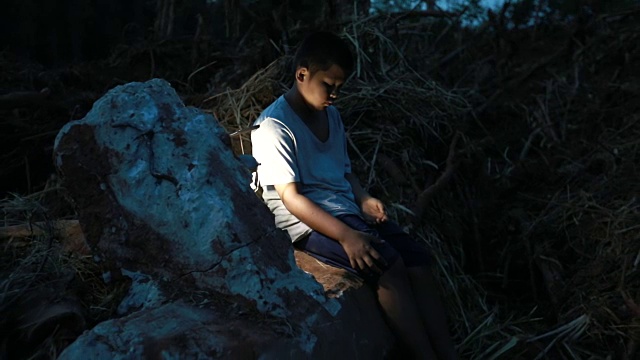 晚上，一个遭受自然灾害的亚洲男孩带着一张悲伤的脸，慢镜头视频素材