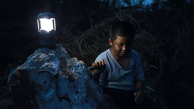 晚上，一个遭受自然灾害的亚洲男孩带着一张悲伤的脸，慢镜头视频素材