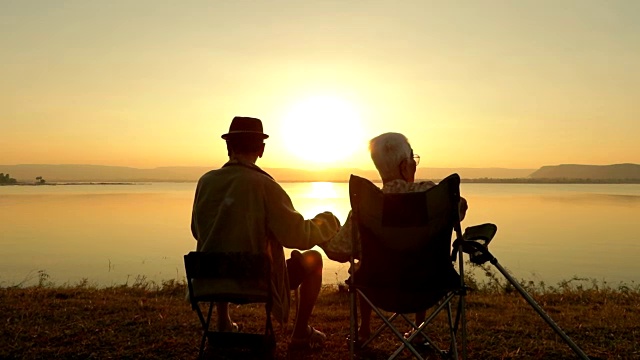 老夫妇在湖边欣赏夕阳，慢镜头视频下载