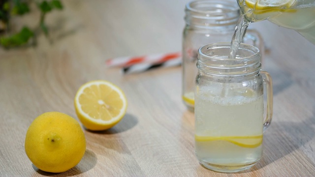 将自制的柠檬水倒入玻璃罐中。视频下载