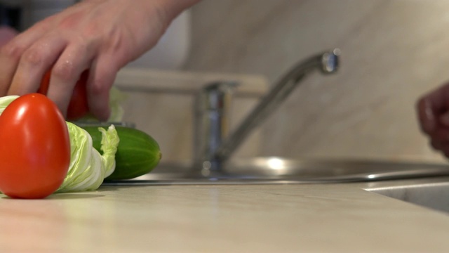 在烹饪素食菜肴前，男子正在清洗新鲜的有机番茄视频下载