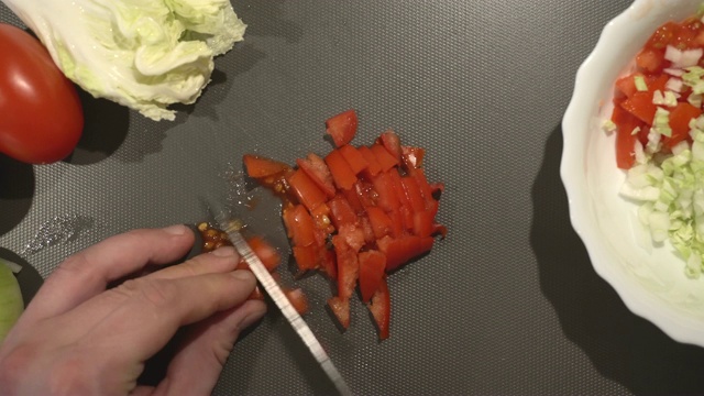 男子正在切新鲜的有机番茄做素食菜肴视频素材