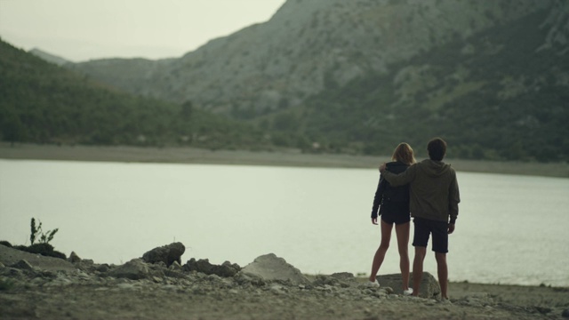 浪漫的情侣拥抱在山湖。日落视频素材