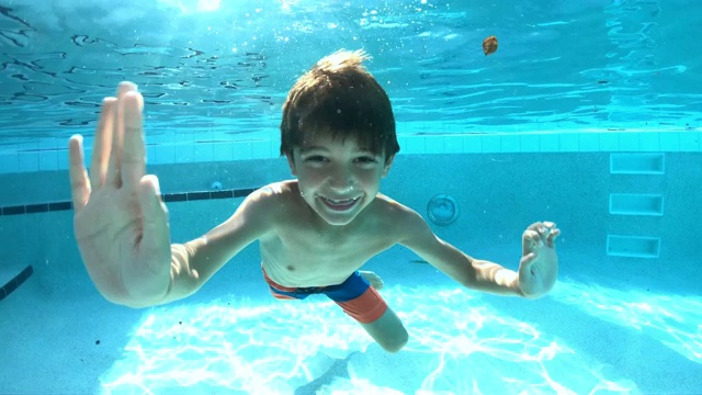 男孩在游泳池里游泳视频素材