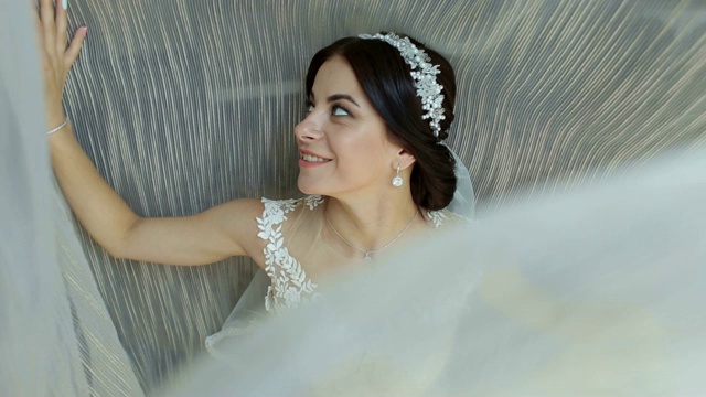 一个蓝眼睛新娘的肖像靠近窗户，她旋转自己。视频下载