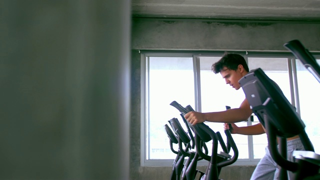 在健身房里用交叉训练器的男人视频素材