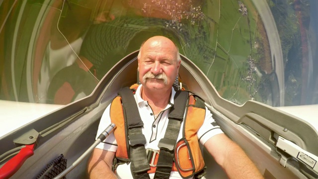 在一个阳光明媚的日子里驾驶滑翔机的资深男飞行员视频素材
