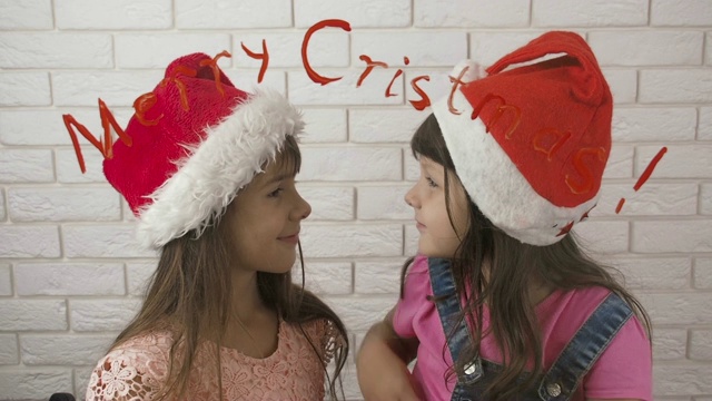 圣诞快乐。孩子们戴着圣诞老人的帽子。视频素材