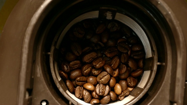 咖啡豆被倒入机器研磨视频下载