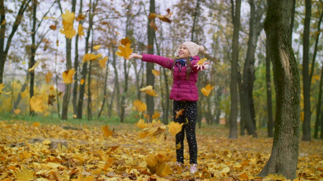 快乐的女孩在户外扔秋叶视频素材