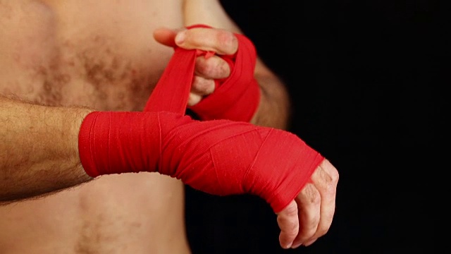 近距离男子拳击手用红色的包裹手腕视频下载