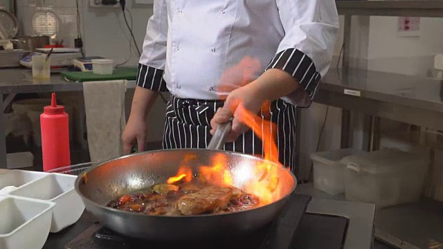 烹饪着火了。厨师用火在平底锅里煮蔬菜和肉。餐厅。意大利菜。健康的饮食习惯。1080便士视频素材