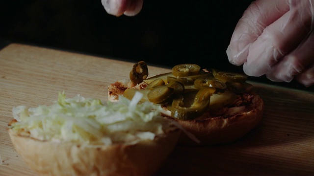 烹饪大汉堡的过程是由专业厨师，特写。把奶酪肉饼放在小圆面包上视频素材