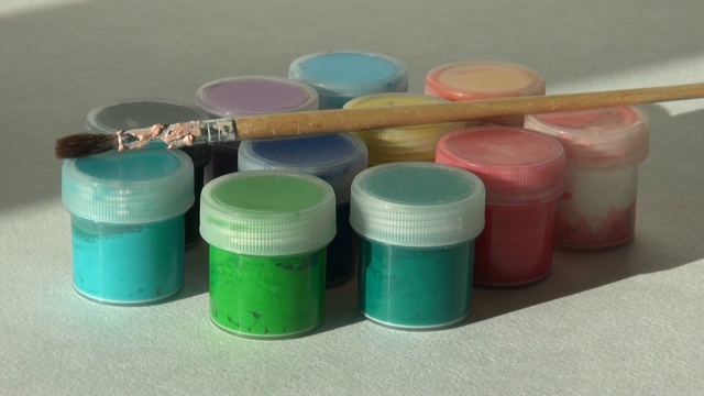 一位艺术家从一罐丙烯酸水粉颜料中拿出一支画笔视频素材