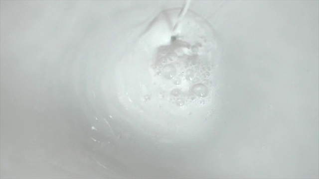 奶油牛奶旋转漩涡和倒与食品乳制品的泡沫背景的镜头视频素材