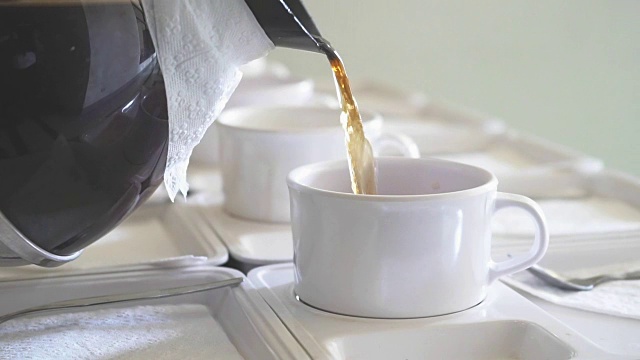 用茶壶将热茶倒入会议用的茶杯中视频下载