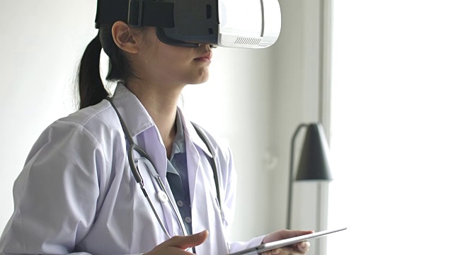 医生戴着虚拟现实眼镜，用数字平板电脑进行模拟体检视频下载