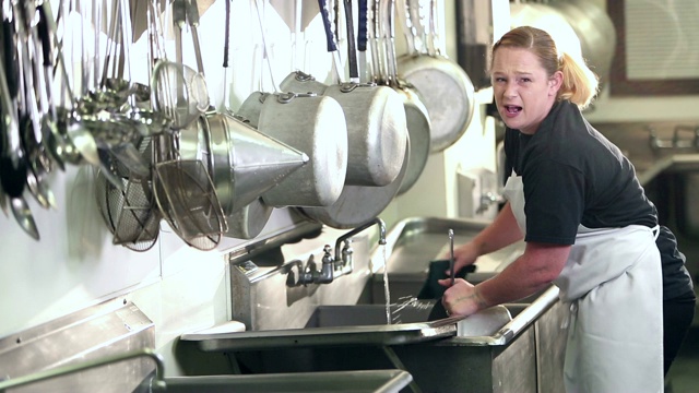 在商业厨房洗碗的妇女视频下载