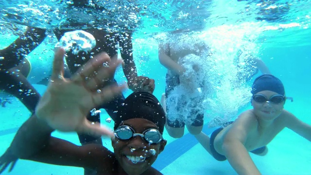 多民族儿童在水下对着镜头挥手视频素材