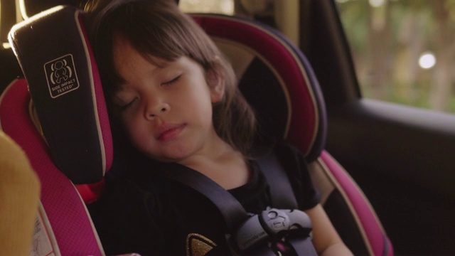 在儿童汽车安全方面。小女孩坐在特制的汽车座椅上视频下载