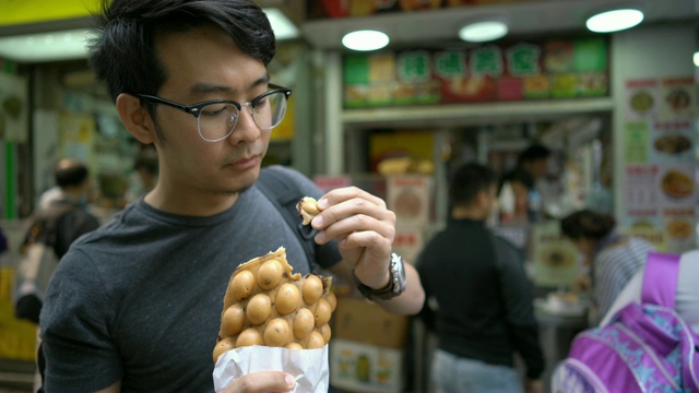 游客品尝香港特色小吃蛋华夫饼/泡泡华夫饼视频下载