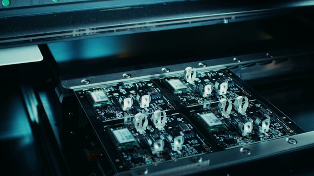 工厂机器在工作:电子PCB被组装与自动数控机械臂，SMT连接微芯片到主板。时间流逝微距特写镜头。使用4K(超高清)摄像机拍摄。视频素材