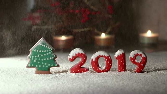 在一棵姜饼树上和数字2019姜饼雪落下。餐桌上的圣诞摆设视频素材