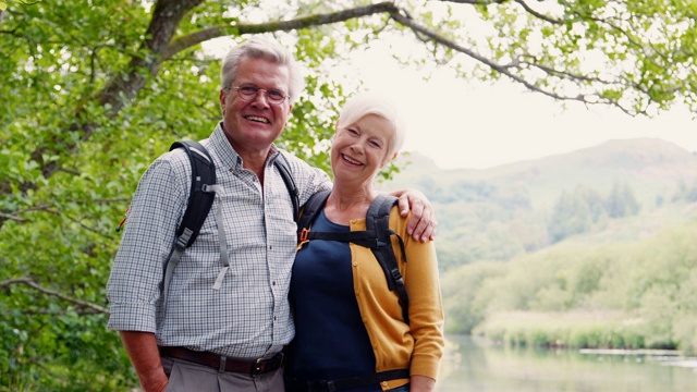在英国湖区沿着河边的小路徒步旅行的老年夫妇的慢动作肖像视频素材
