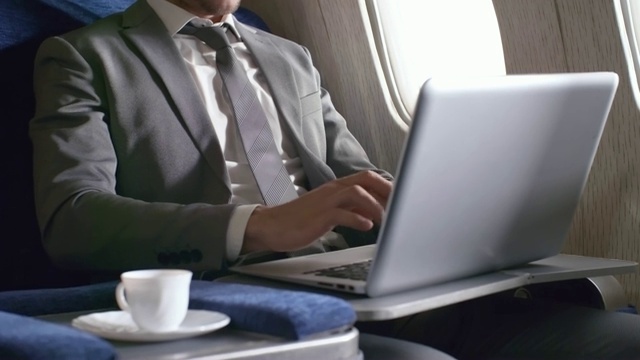 忙碌的商人在飞机上用笔记本电脑工作视频素材